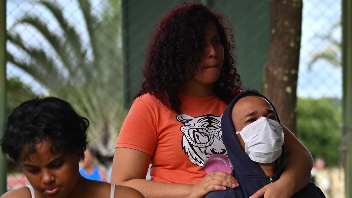 Personas esperan para recibir atención médica en una tienda de campaña para tratar casos sospechosos de dengue en Brasil.