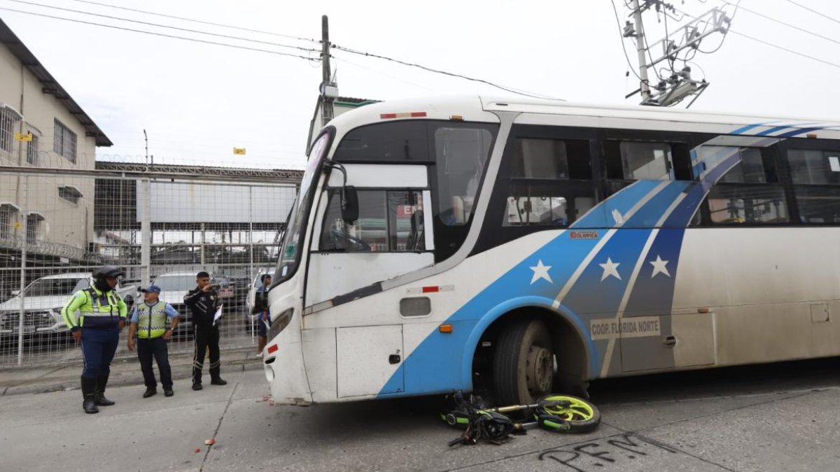 La moto quedó debajo del transporte urbano, mientras que los cascos de los ocupantes quedaron tirados en la avenida.