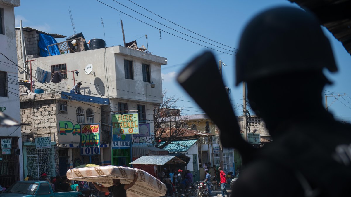 Un policía vigila, cuando la tensión volvió este viernes a Puerto Príncipe con tiroteos entre la Policía y las bandas armadas, después de que la capital haitiana amaneciera en aparente calma.
