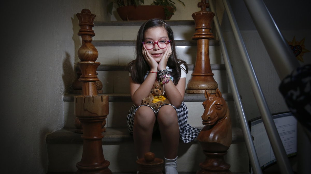 La pequeña no ha perdido la inocencia, mientras habla abraza sus peluches. Juega al ajedrez y estudia astrofísica, artes plásticas y robots.