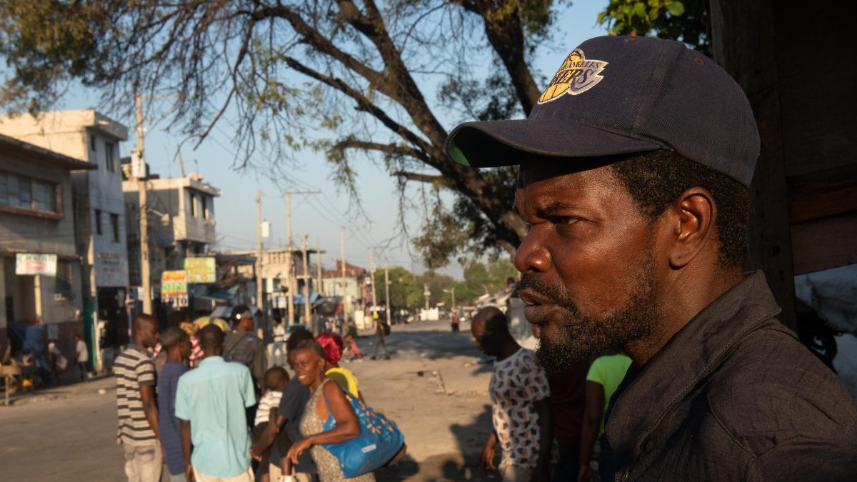 Personas caminan cerca a la Penitenciaría Nacional este domingo, en Puerto Príncipe (Haití). .