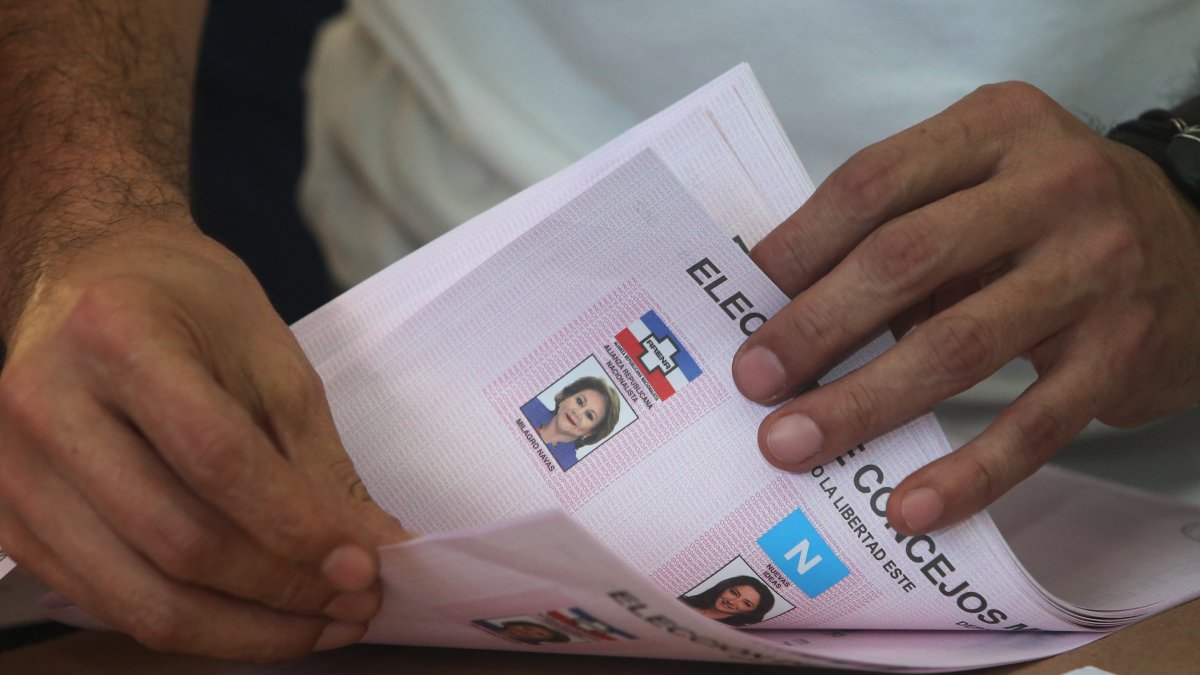 Un miembro de junta receptora de votos cuenta papeletas sobrantes al final de la jornada electoral el 3 de marzo.