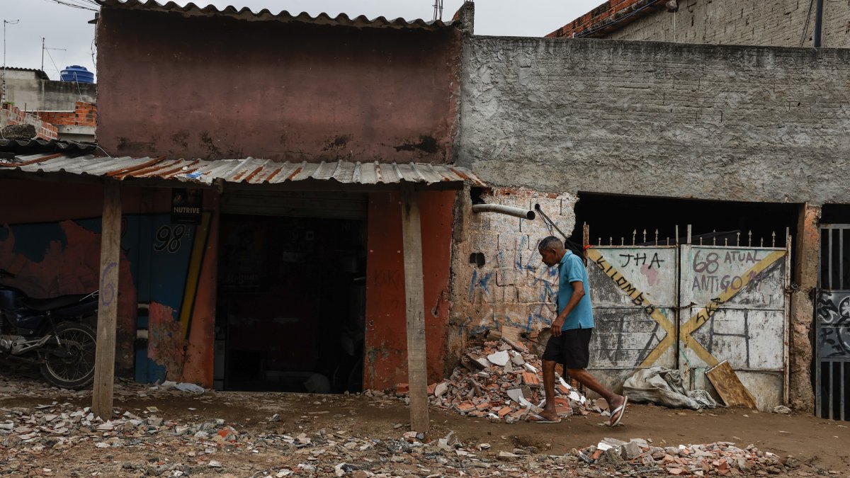 Un hombre camina entre escombros en el barrio Jardim Pantanal en Sao Paulo