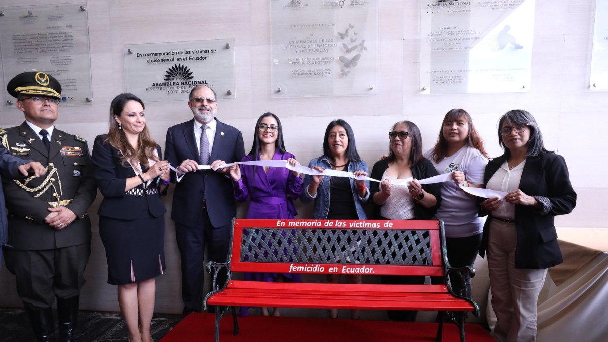 Símbolo. Entre dos aliadas correístas, en la plaza de acceso al salón plenario, el presidente Henry Kronfle inaugura el banco rojo contra el femicidio.