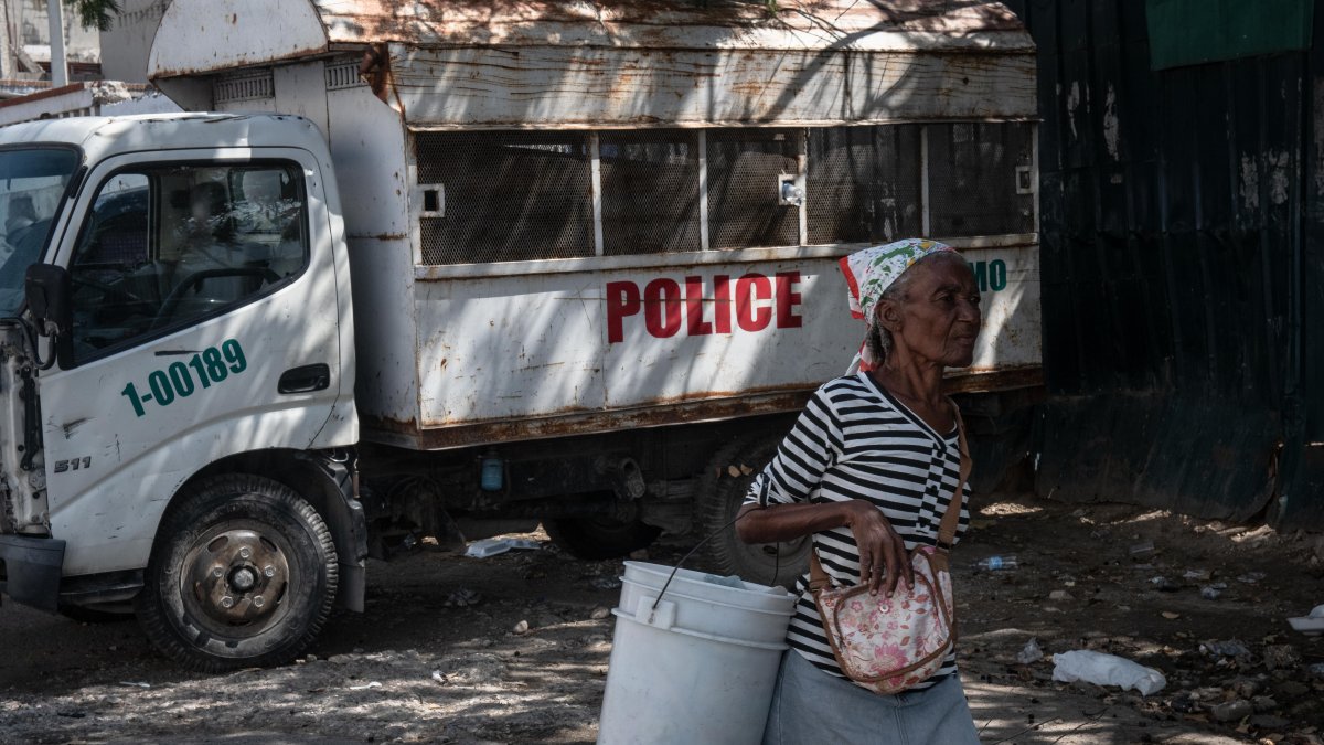 Caso. Una mujer camina frente la prisión nacional, en Puerto Príncipe, donde se dio una de las fugas masivas.