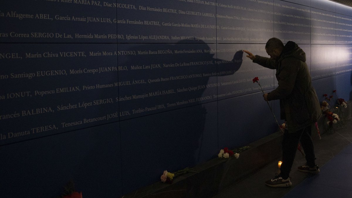 Una persona deposita un clavel en memoria de las víctimas del 11-M.