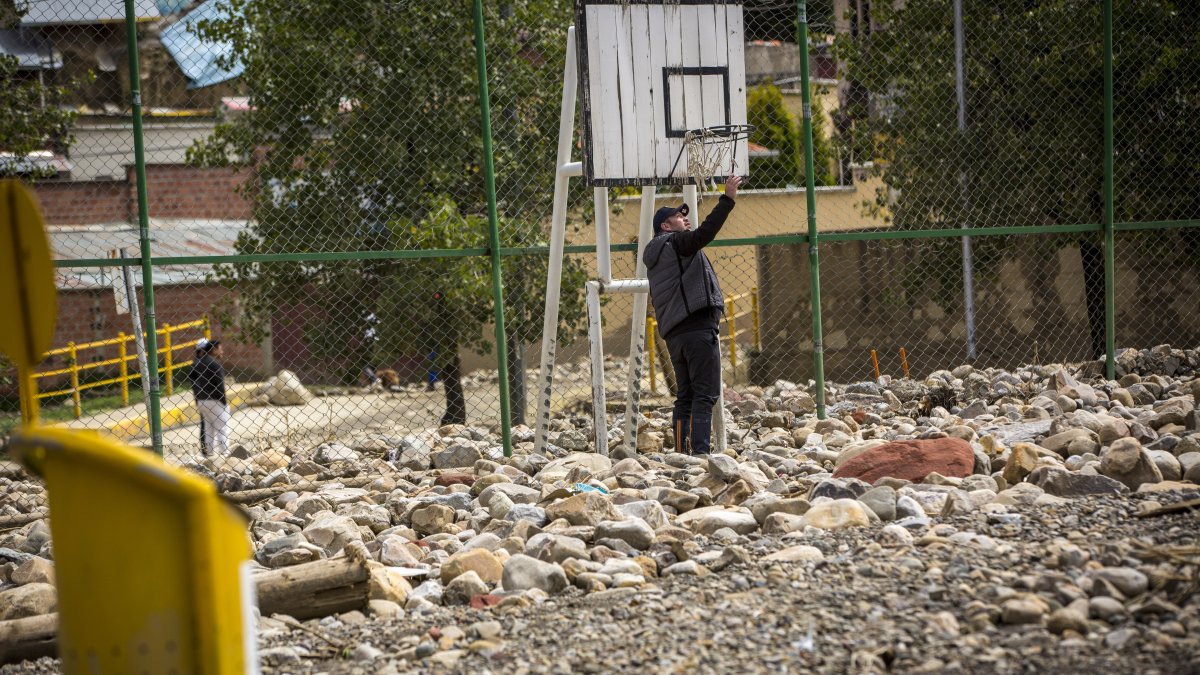 Una persona camina en medio de las piedras y escombros que quedaron en un parque tras el desborde de un río, el 9 de marzo, en La Paz.