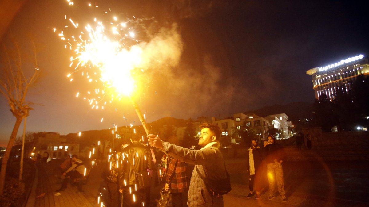 Un grupo de personas comparte la celebración de la milenaria fiesta del fuego en Irán, la noche del martes 12 de marzo