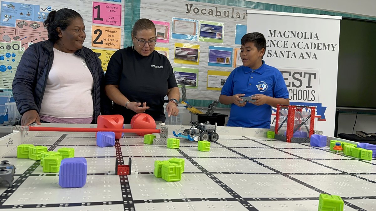 Aracely Vargas (i), su hijo, el estudiante de sexto grado Joel Rodrigue durante su participación en la primera Competencia Anual de Robótica VEX