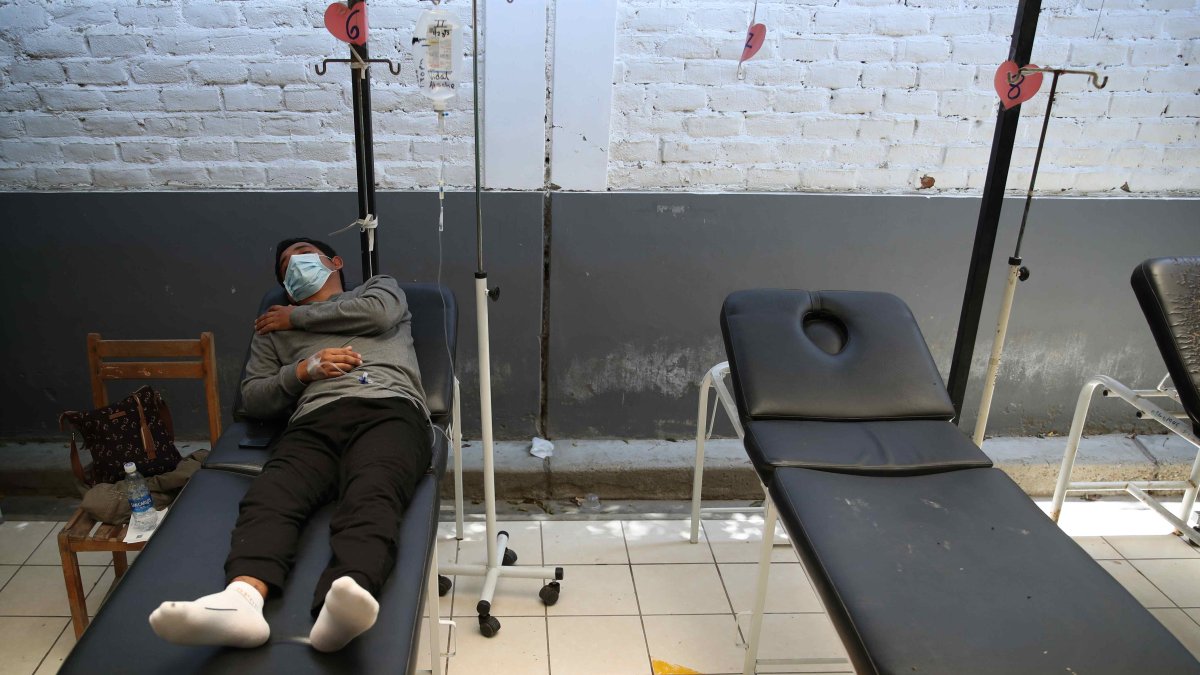 Panorama. Un hombre con dengue que yace en una camilla.