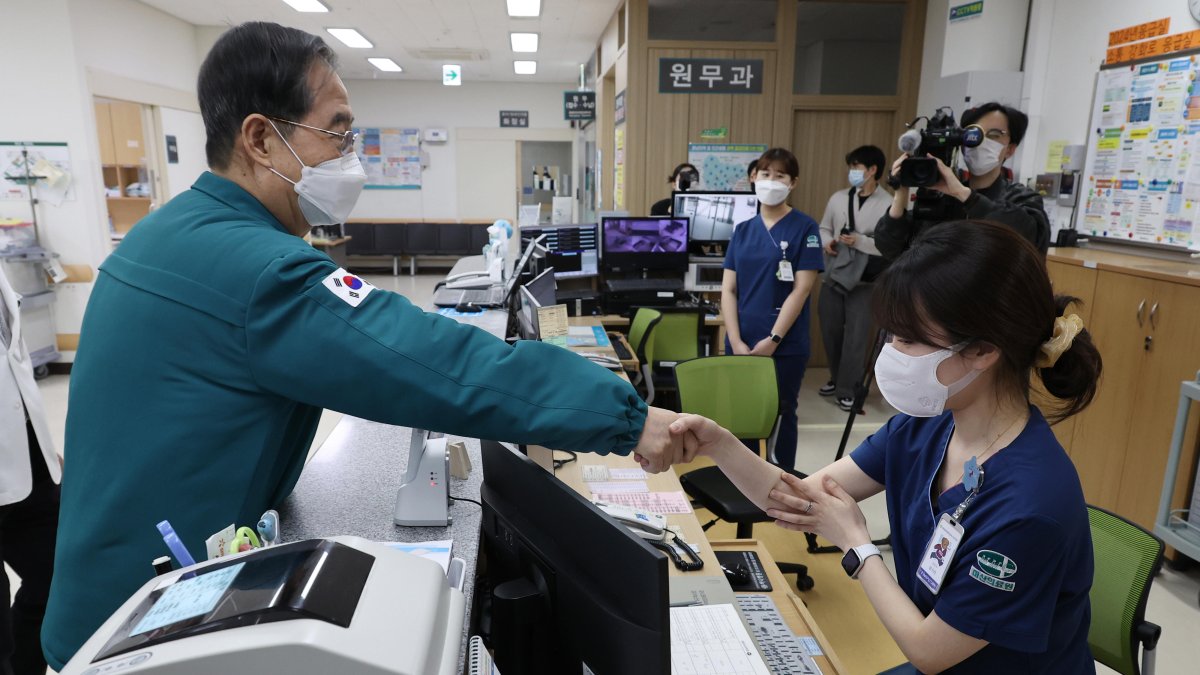 El primer ministro surcoreano, Han Duck-soo, le da la mano a una enfermera durante una visita al Centro Médico Masan en Masan, a unos 298 km al sureste de Seúl, en medio de una huelga en todo el país.