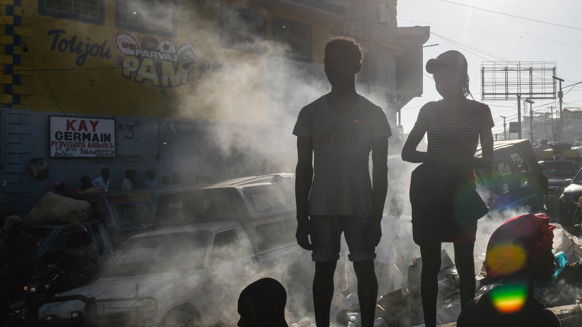 Varias personas observan el cadáver de una persona en el suelo este lunes 18 de marzo de 2024, en Puerto Príncipe (Haití).