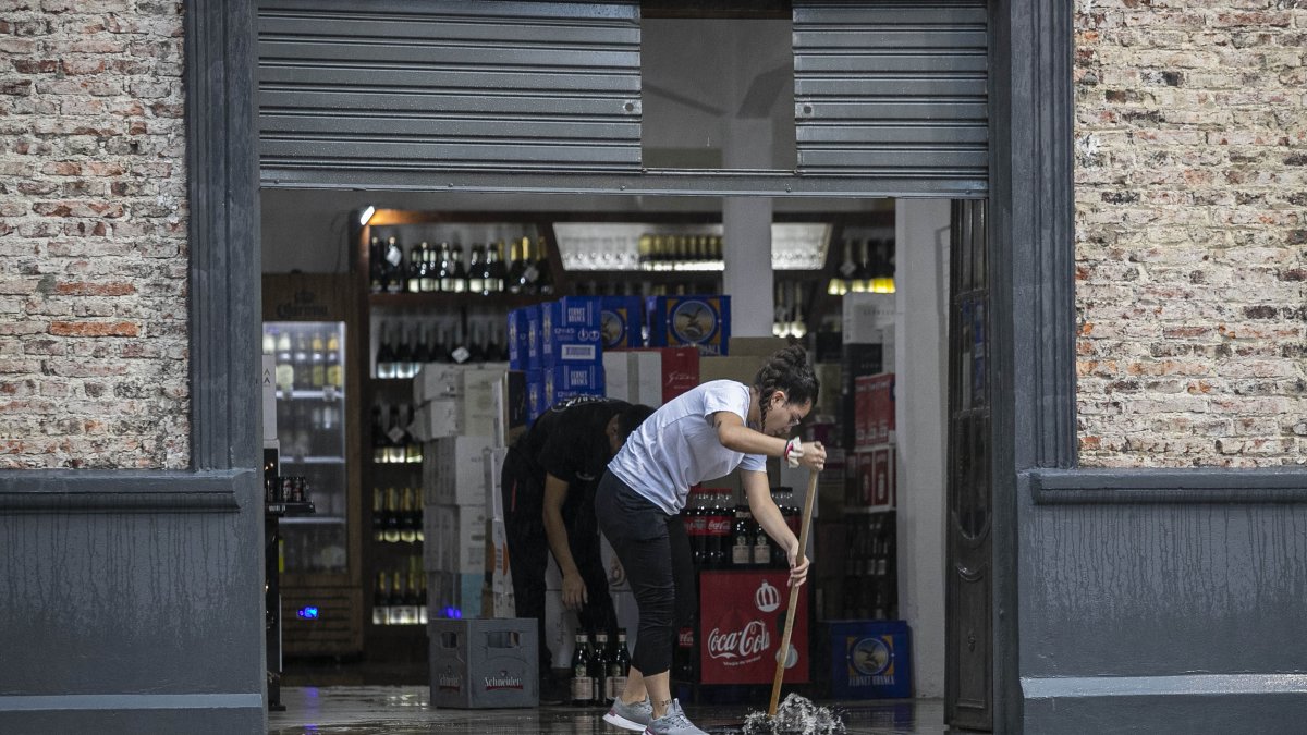 Una persona evacua el agua de su negocio en medio de un aguacero este miércoles 20 de marzo de 2024, en La Plata, provincia de Buenos Aires (Argentina).
