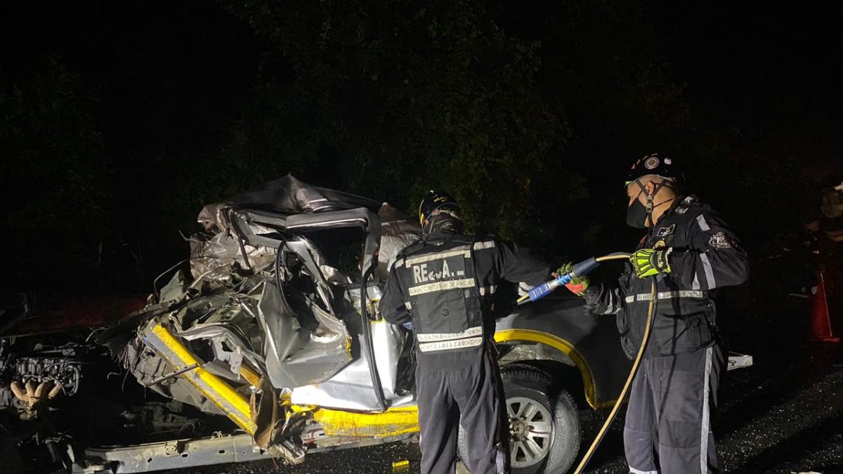 Uniformados durante la tareas de extracción de cuerpos de un vehículo accidentado.