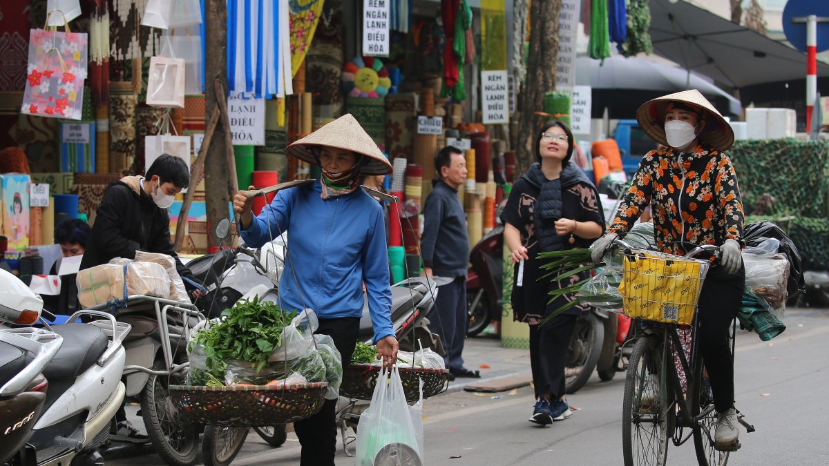 Un vendedor ambulante que camina por una calle de Hanoi, en Vietnam, 13 de marzo de 2024
