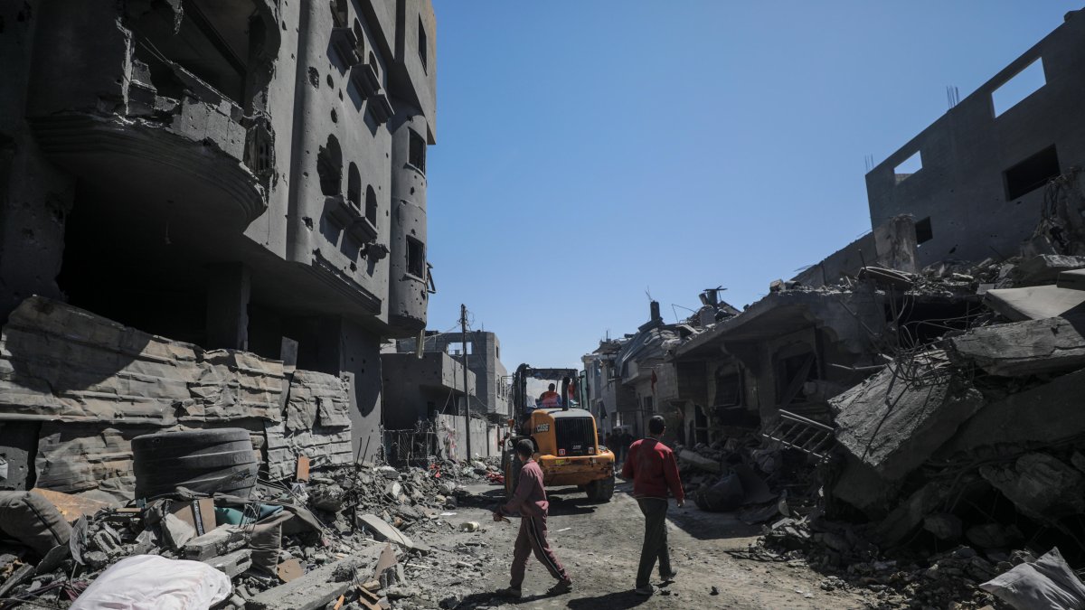 Palestinos buscan personas desaparecidas bajo los escombros de una casa destruida tras un ataque aéreo israelí, en el campo de refugiados de Al Nusairat, sur de la Franja de Gaza, 20 de marzo de 2024.