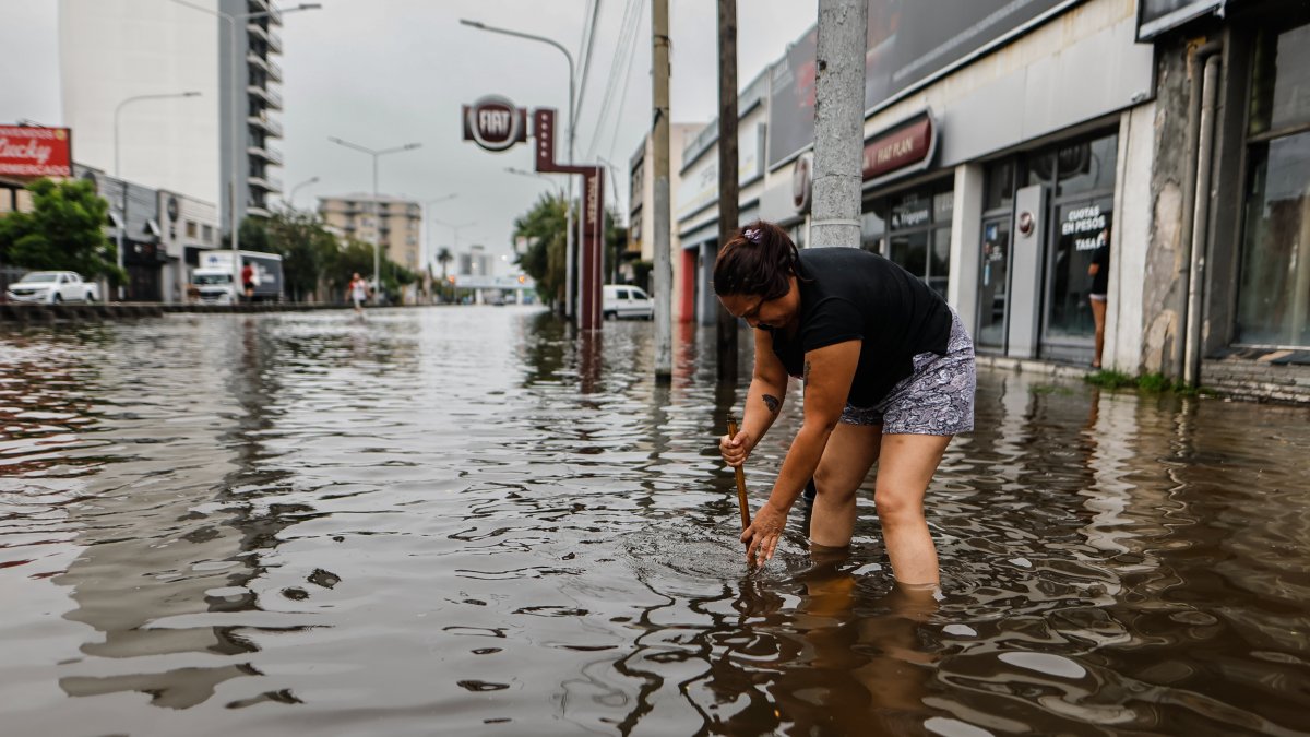 Una mujer en medio de una calle inundada por la lluvia el 20 de marzo de 2024, en Buenos Aires