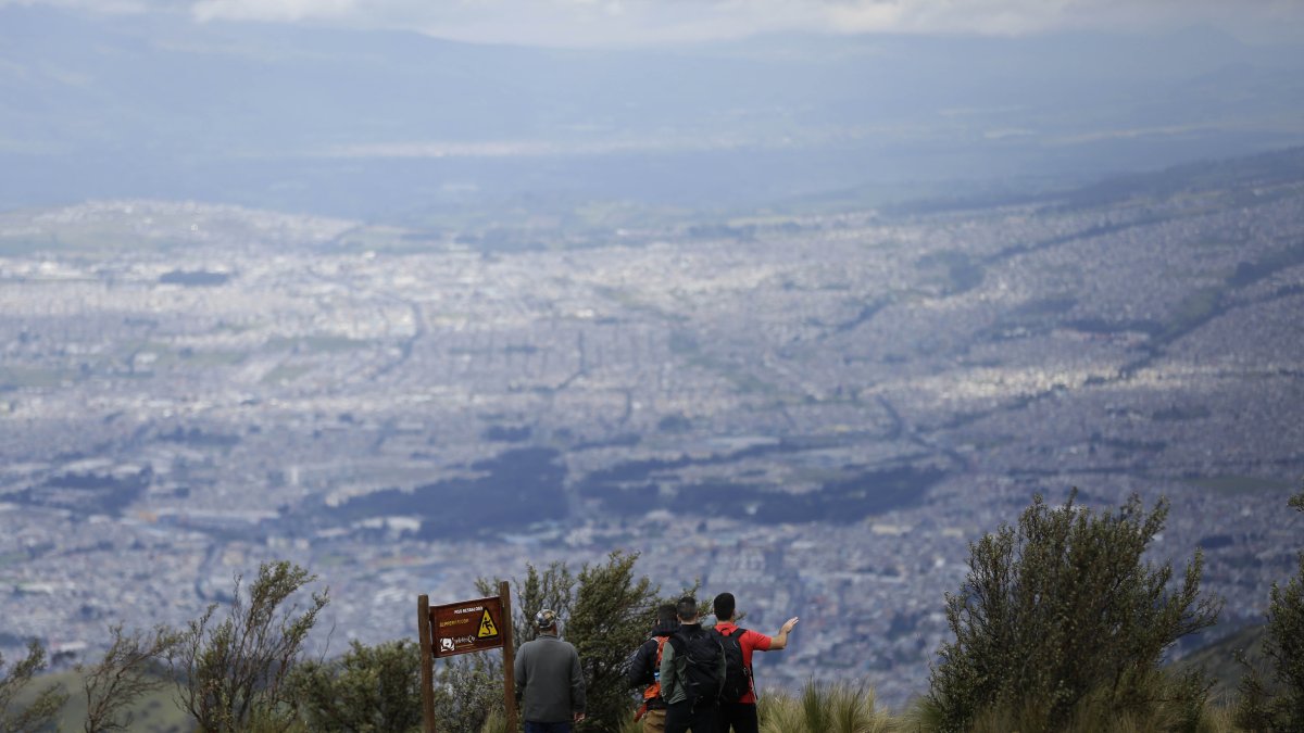Un grupo de turistas visitan el teleférico en Quito.