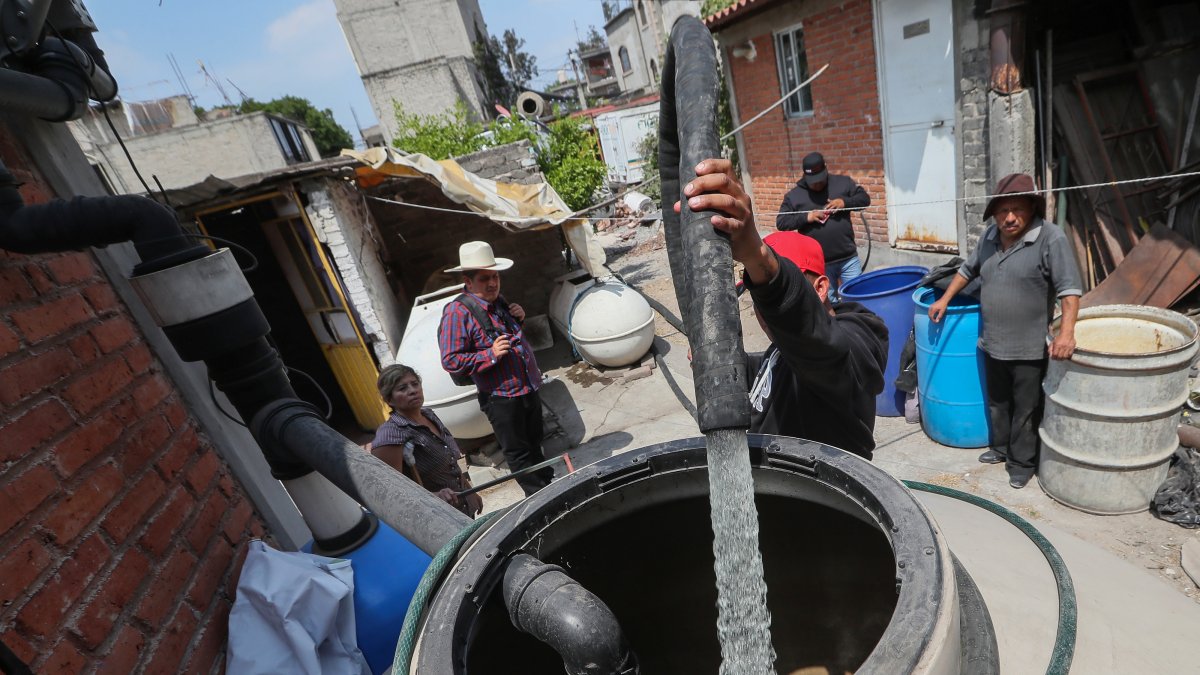 Un hombre llena unos tanques con agua, el 19 de marzo del 2024, en el pueblo de Santa María Aztahuacan, en la Ciudad de México (México).