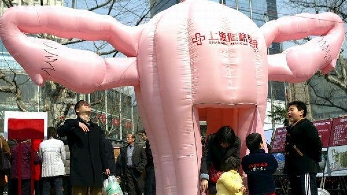 Visitantes observan una réplica hinchable de un útero humano en un áera comercial de Shanghai,