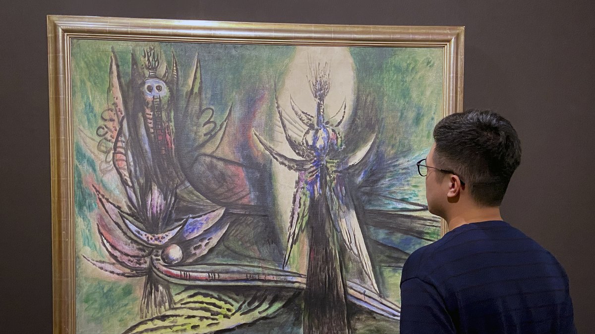 Un visitante observa las obras del artista cubano Wifredo Lam