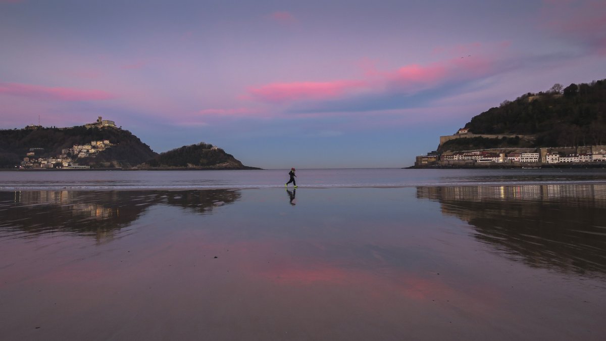 Archivo. Dos personas corren al amanecer por la orilla de la playa de La Concha de San Sebastián