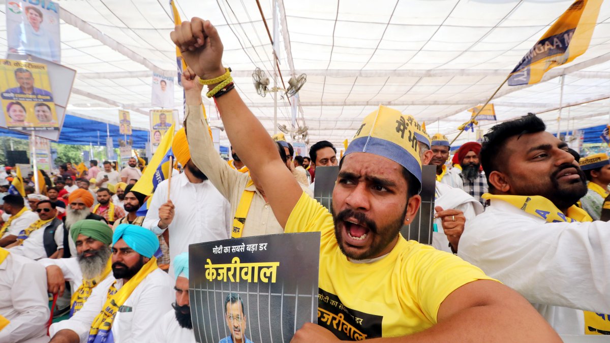 Partidarios del partido Aam Admi (AAP) y miembros de la Alianza Inclusiva de Desarrollo Nacional de la India (I.N.D.I.A) gritan consignas y sostienen pancartas en apoyo de Kejriwa.