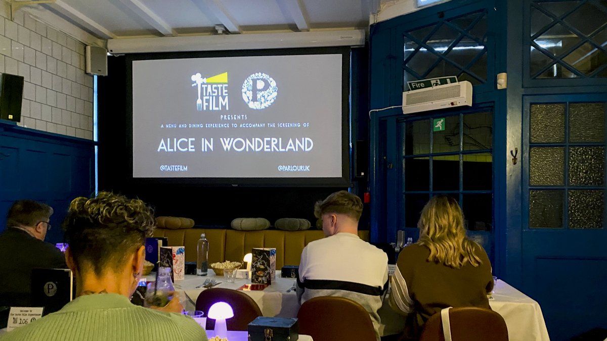 Instantes previos a la emisión de la película 'Alicia en el país de las maravillas' en un restaurante de Londres.