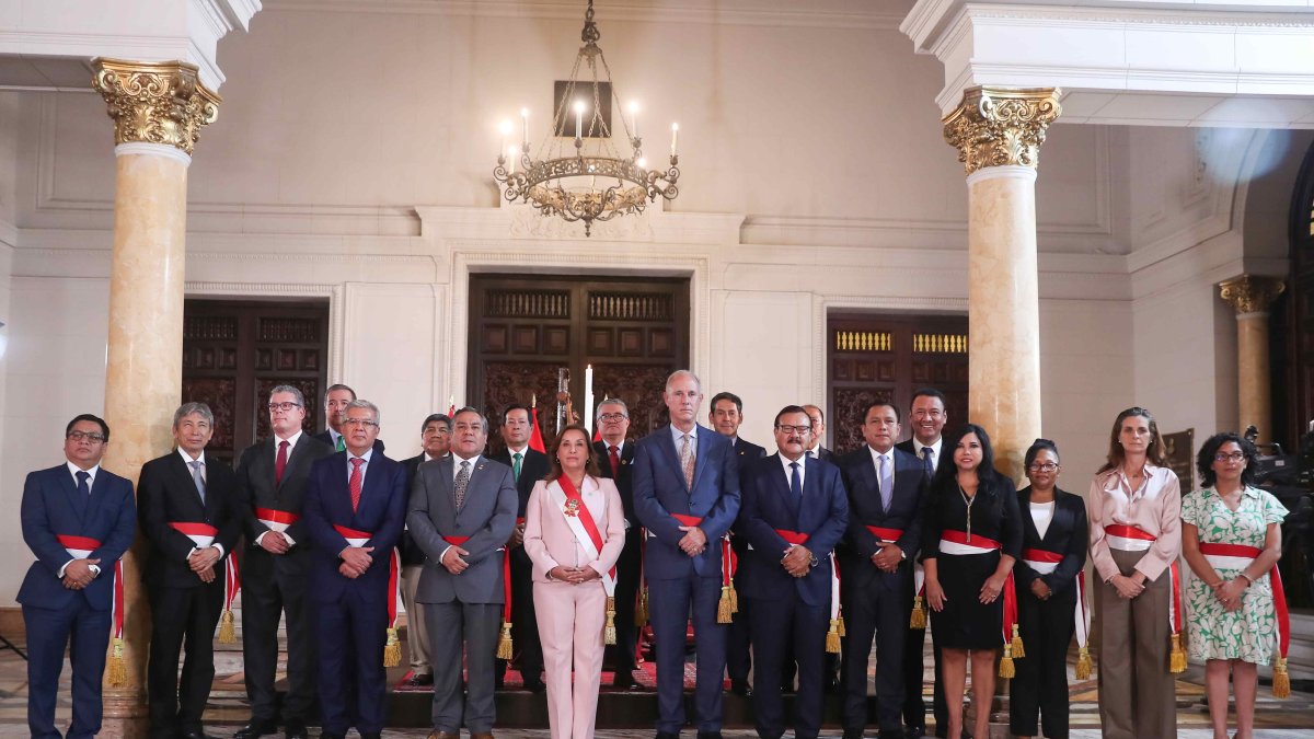 La mandataria, Dina Boluarte, mientras posa junto a los nuevos integrantes de su gabinete de ministros, este lunes en Lima (Perú).