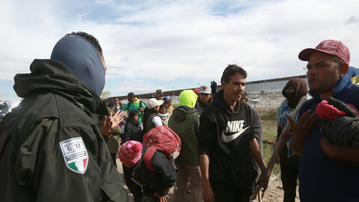 Personal del Instituto Nacional de Migración (INM) y un grupo de migrantes dialogan tras un enfrentamiento este martes 2 de abril de 2024, en las inmediaciones de la frontera, en Ciudad Juárez.