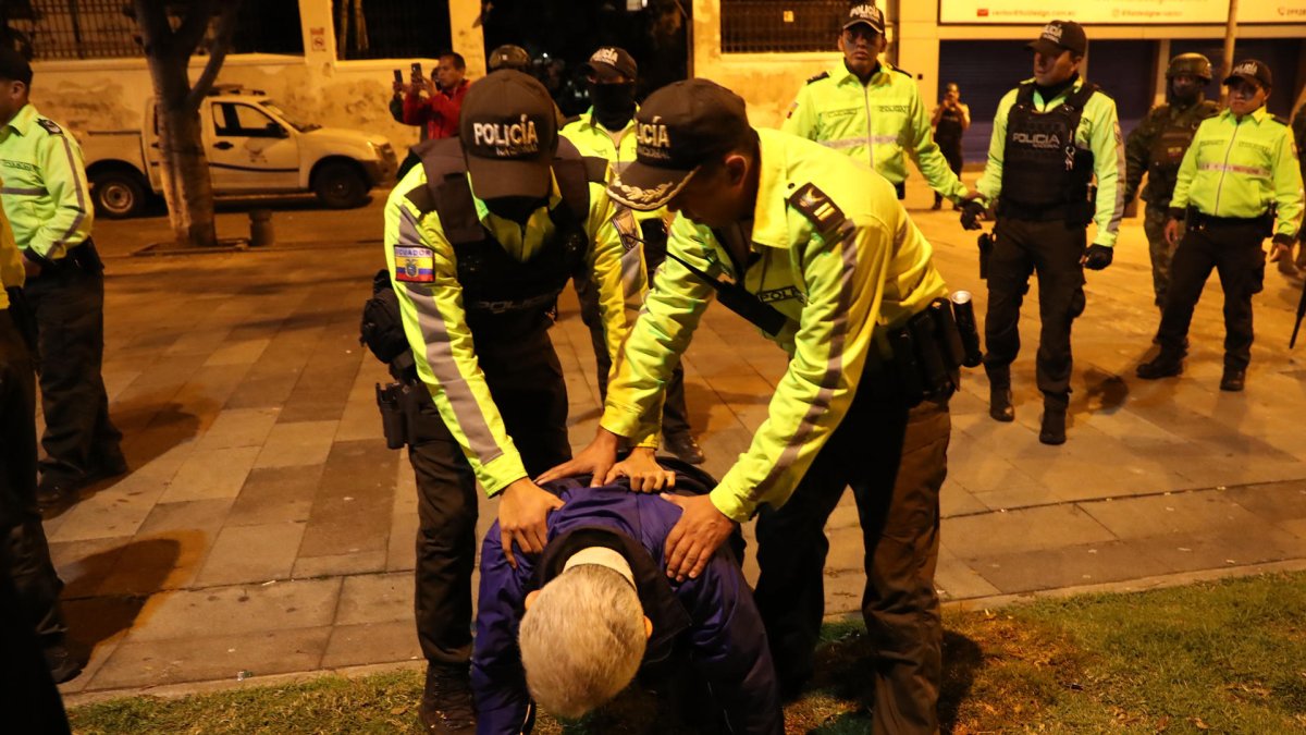 El jefe de Cancillería y Asuntos Políticos de la Embajada de México, Roberto Canseco, forcejea con policías.
