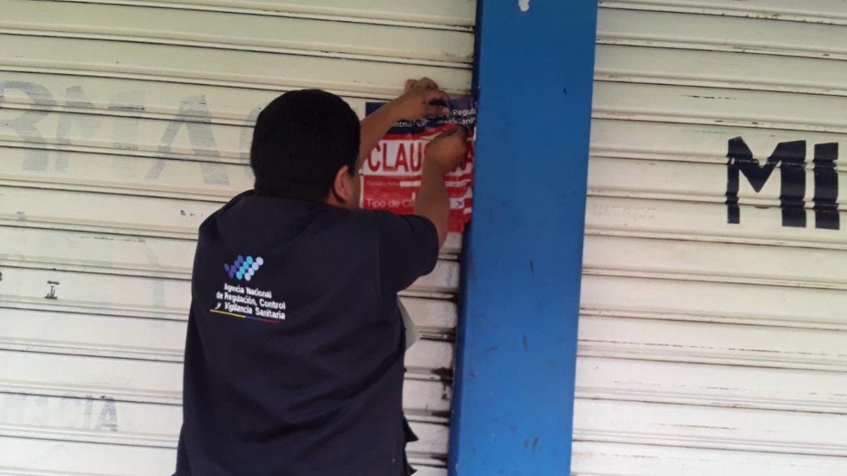 Medida.- Un delegado de Arcsa pone el sello de clausura a una farmacia.