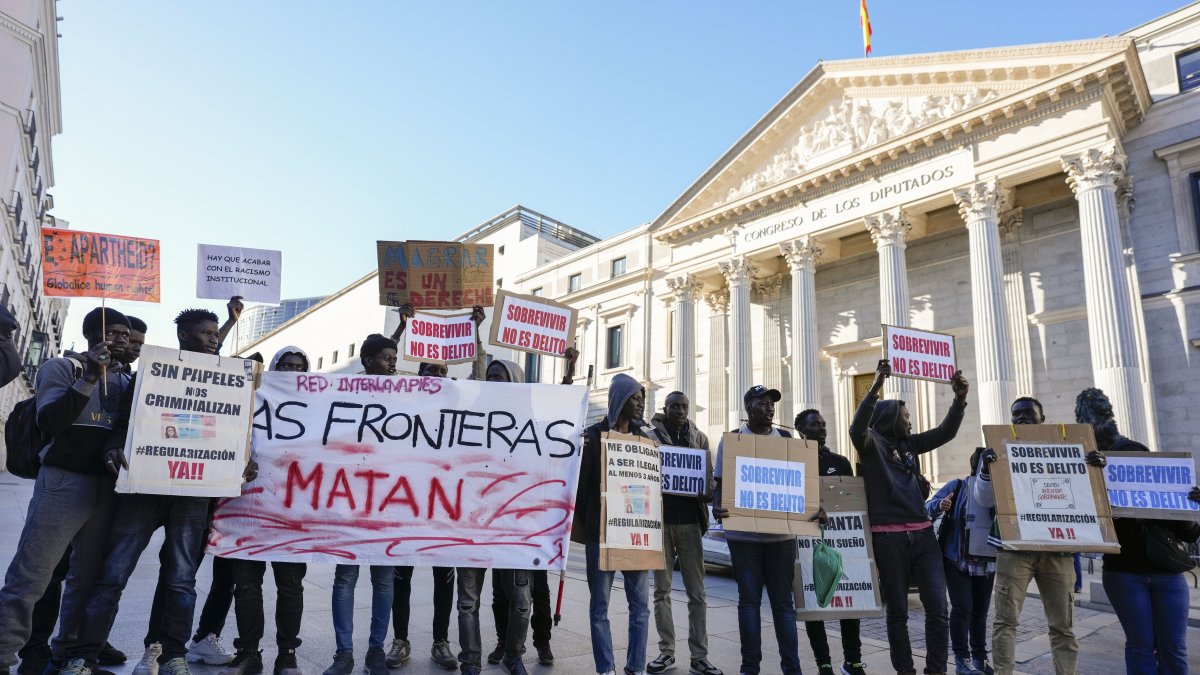 Integrantes de entidades sociales impulsoras de la iniciativa legislativa popular se manifiestan durante el debate en el pleno del Congreso de los Diputados, en Madrid.