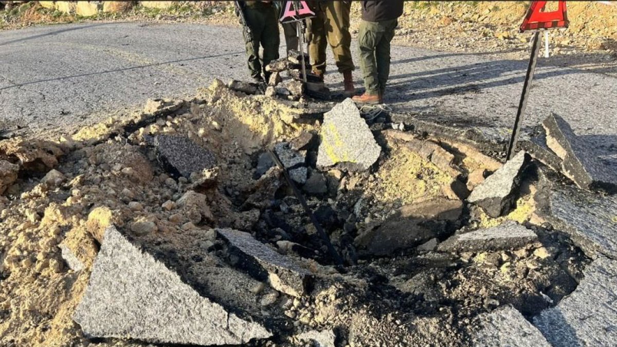 Fotografía cedida este domingo por el Ejército de Israel de los daños causados en una vía durante la oleada de drones, misiles y misiles balísticos.