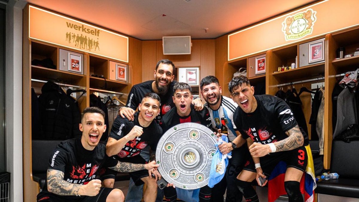 El ecuatoriano Piero Hincapié (d) junto a sus compañeros y el plato de campeón en el vestidor del Bayer Leverkusen.
