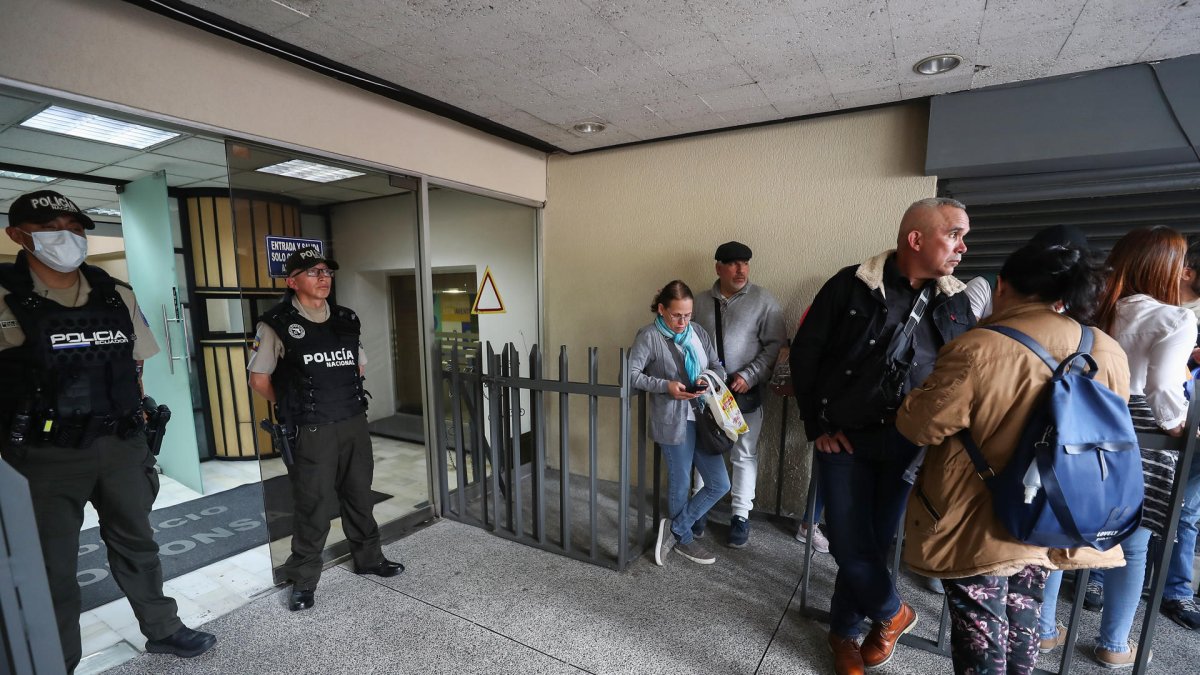 Ciudadanos venezolanos esperan información a las afueras del consulado de Venezuela, tras el anuncio del presidente Nicolás Maduro del cierre de la Embajada y consulados, en Quito (Ecuador).