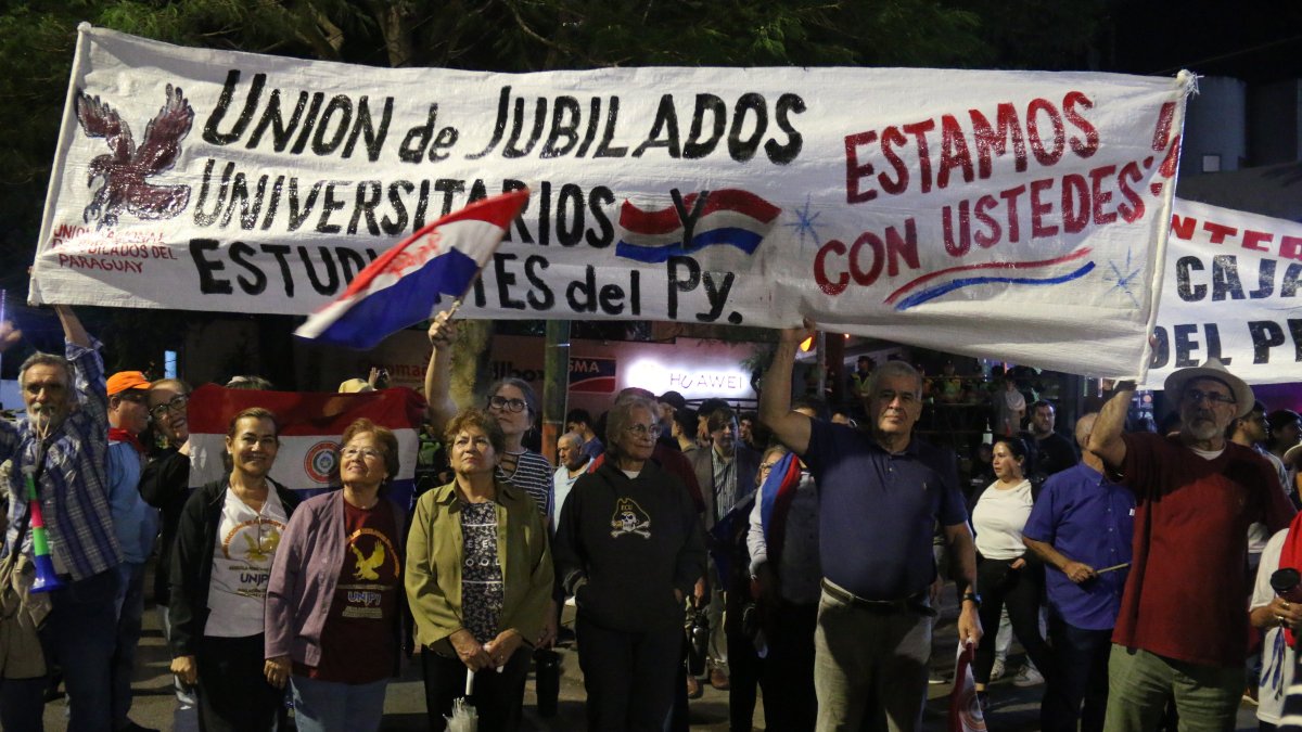 Integrantes de la Unión de Jubilados de Paraguay participan en una manifestación de estudiantes que exigen que se garanticen los recursos que financien el programa 'Arancel Cero', en Asunción.
