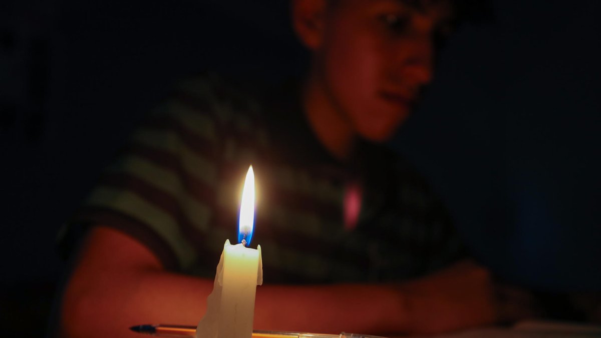 Un estudiante lee un texto a la luz de una vela este miércoles en Quito (Ecuador).