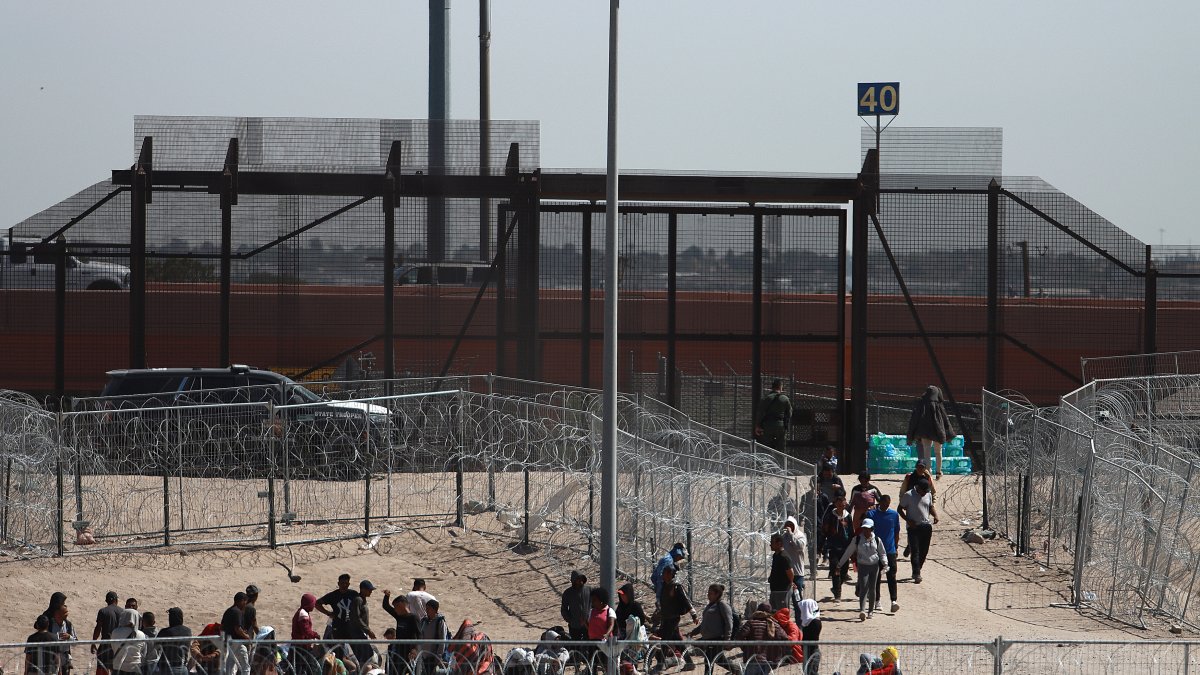 Migrantes aparecen en la frontera con Estados Unidos, este jueves en Ciudad Juárez (México).