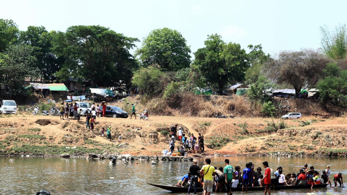 BIrmanos cruzan el río Moei en la frontera entre Birmania y Tailandia para huir de los enfrentamientos entre las fuerzas pro y anti junta militar.