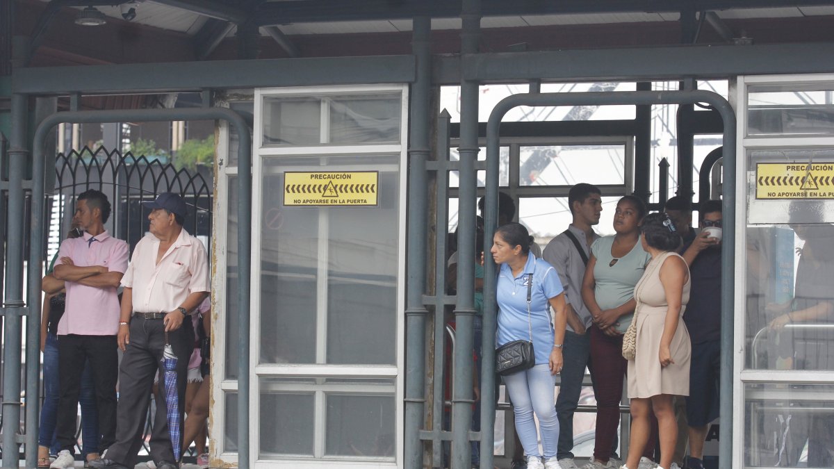 Las personas esperan los buses en las paradas