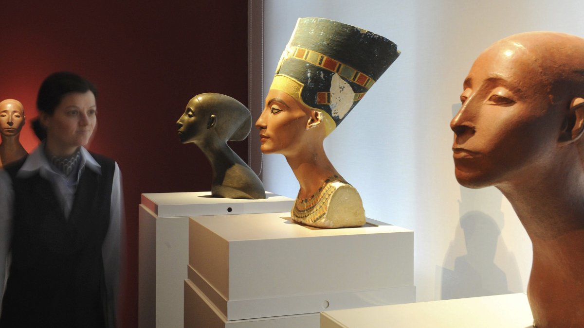 Una mujer que observa el busto de Nefertiti