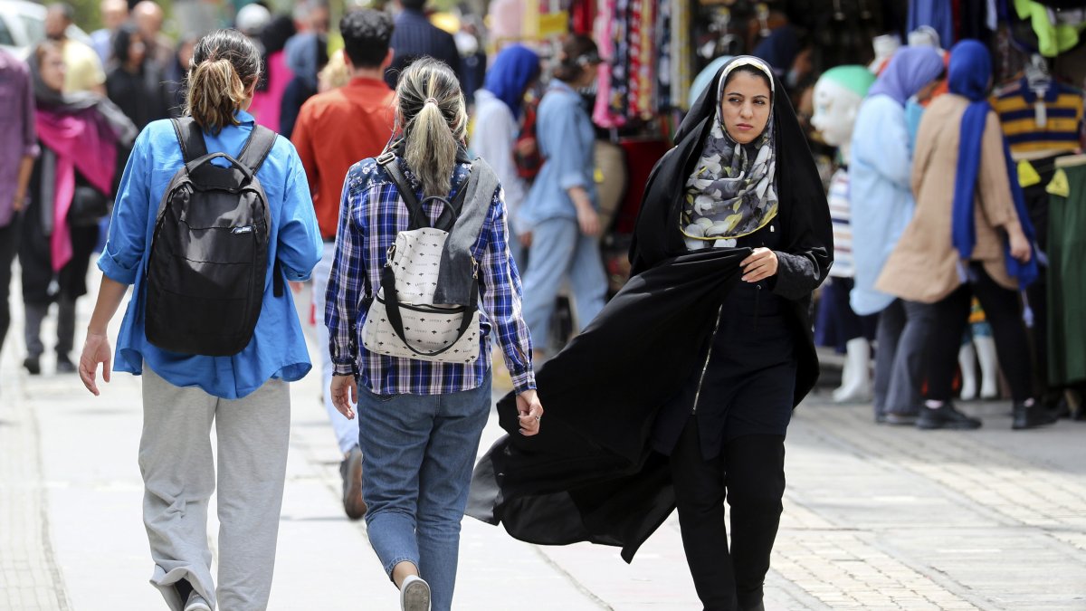 Varias mujeres con y sin velo caminando por una calle de Teherán (Irán).