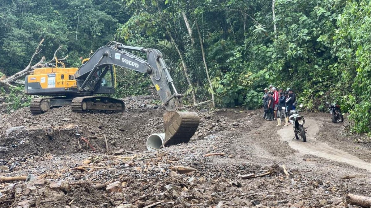 Los vehículos atraviesan con cautela el camino provisional abierto en la carretera afectada por deslaves.