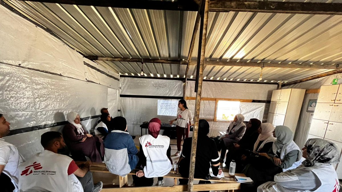 El equipo de MSF conversa con un padre y su hijo (tiene una pierna lastimada), en el establecimiento de MSF en Al Mawasi, Franja de Gaza.