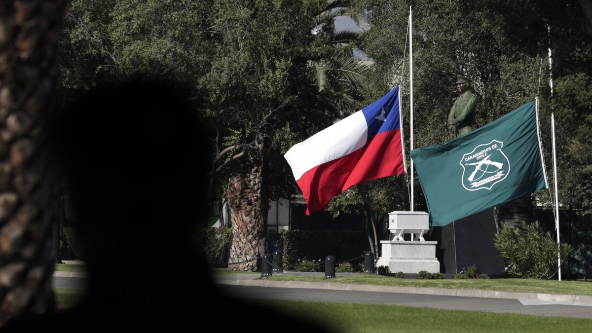 Las banderas de Chile y la institución de Carabineros a media asta en la Escuela de Carabineros, este sábado en Santiago (Chile).