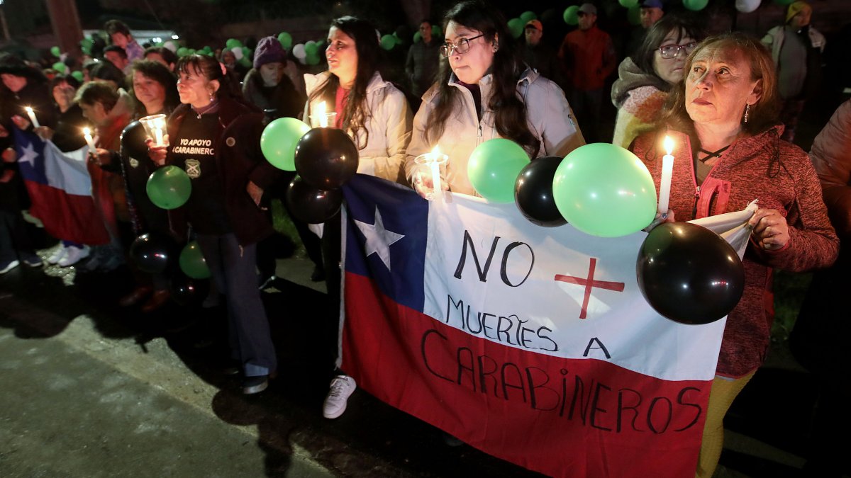 Un grupo de personas se reúne para rendir y homenaje y despedir a los tres policías asesinados tras un ataque el sábado en la región, en la región del Bío Bío (Chile).