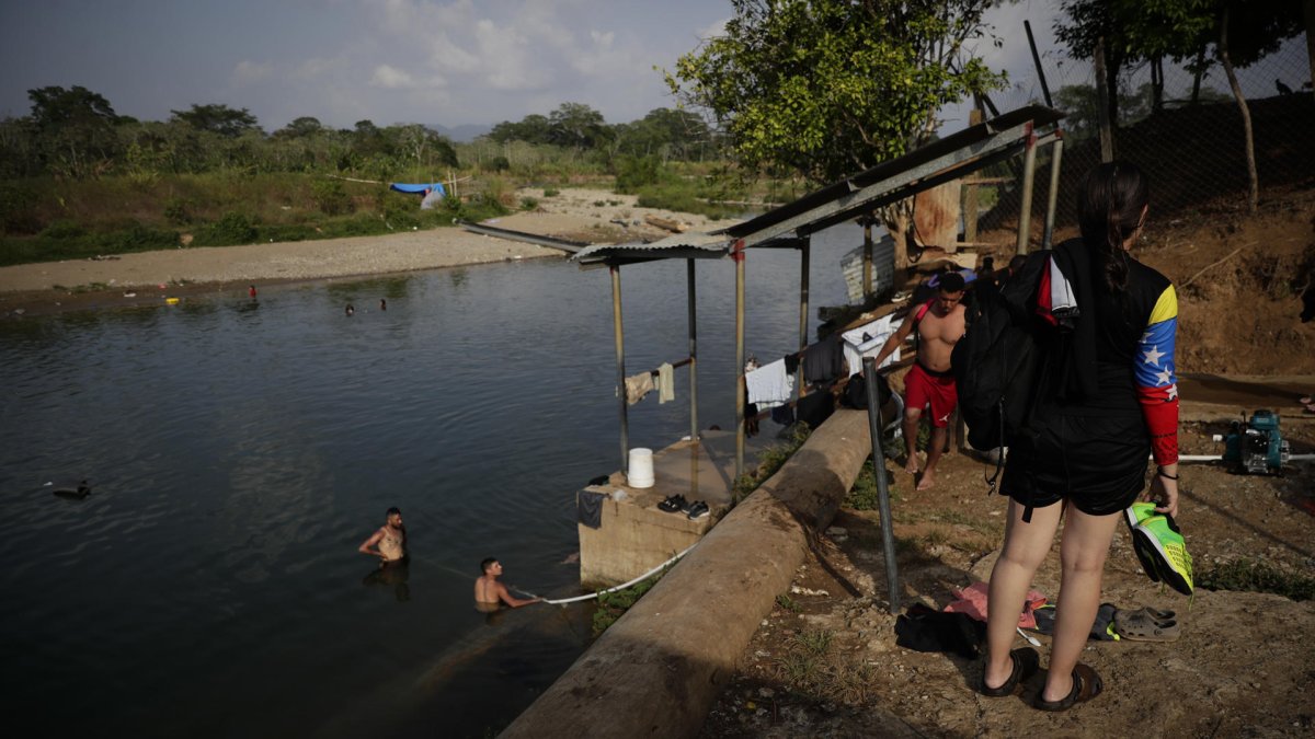 Migrantes se bañan luego de cruzar la selva del Darién con rumbo a los Estados Unidos, el 9 de abril de 2024, en el poblado de Bajo Chiquito (Panamá).