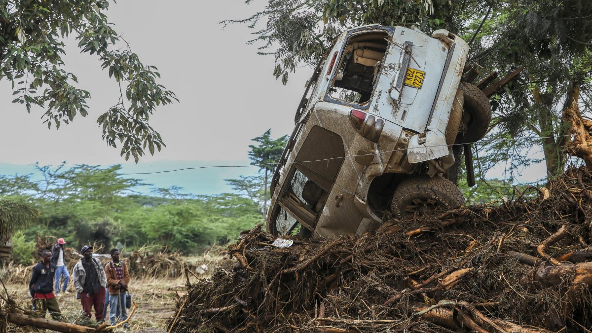 Nairobi. Personas observan un carro que fue arrastrado por un río.