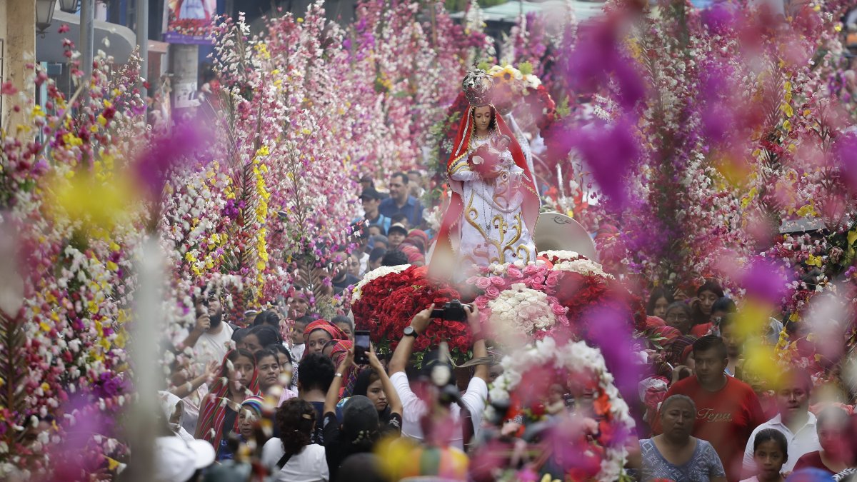 Una multitud participa del festival de Flores y Palmas, dedicado a la Virgen de Concepción, este domingo en Panchimalco (El Salvador).